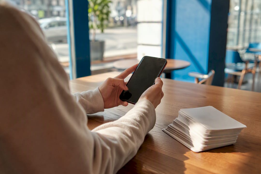 Hands holding smartphone voice recorder in study space