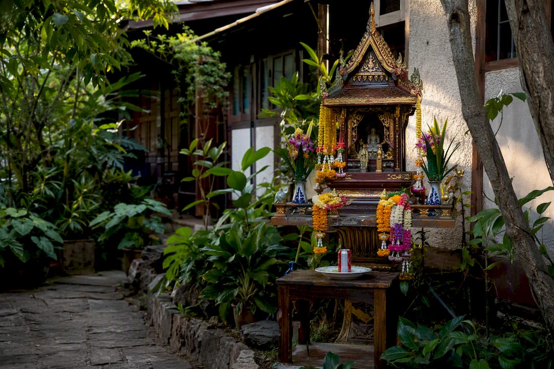 Traditional Thai spirit house with offerings