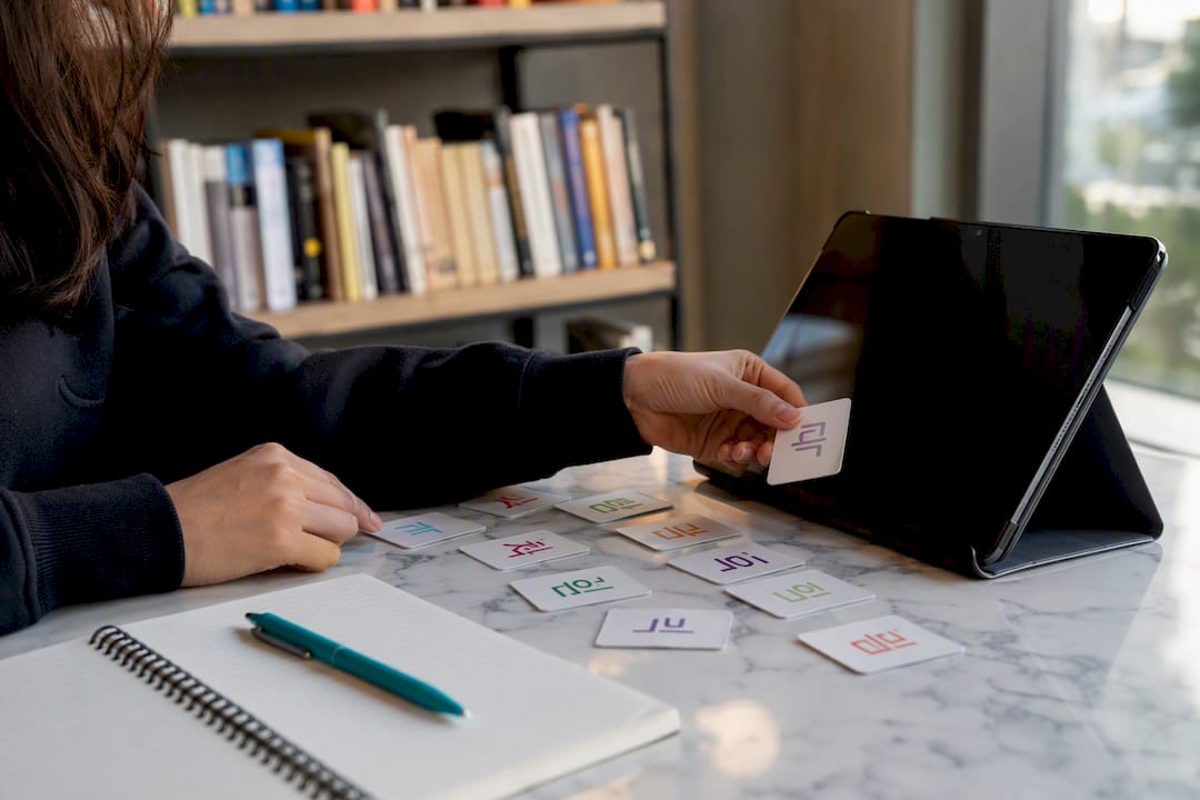 Hands with Korean test materials on table