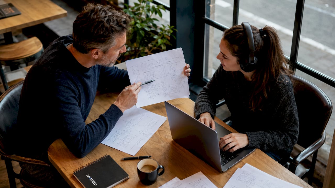 Zwei Menschen lernen gemeinsam in einer modernen Coworking-Atmosphäre – jeder für sich, aber doch zusammen.