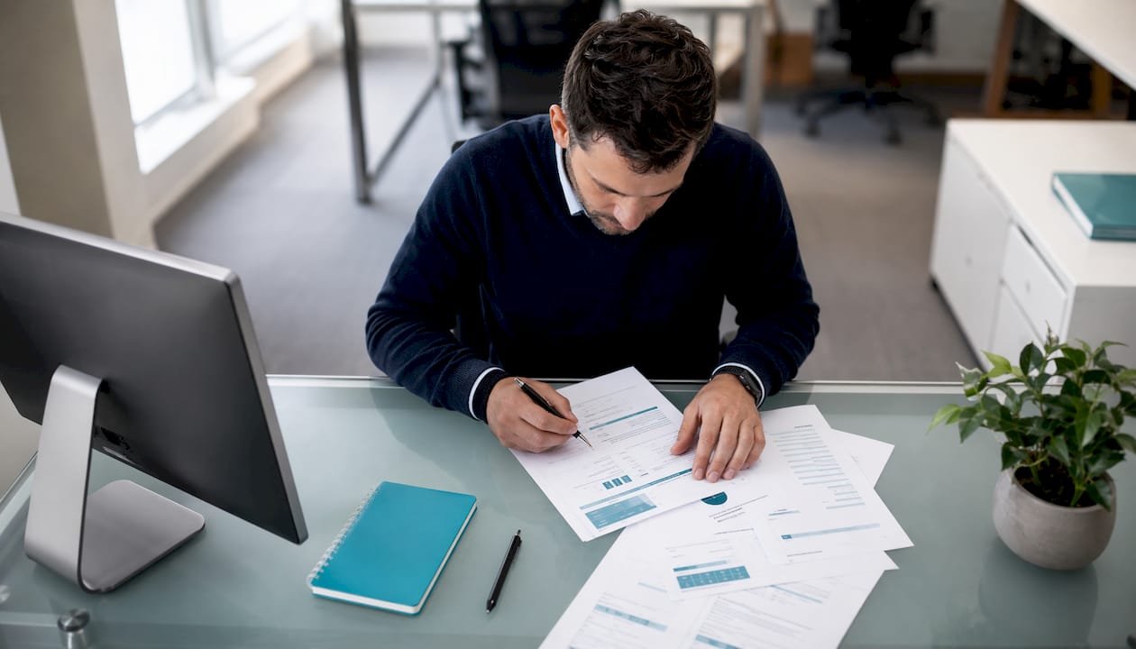 Accountant organizing entity paperwork at desk