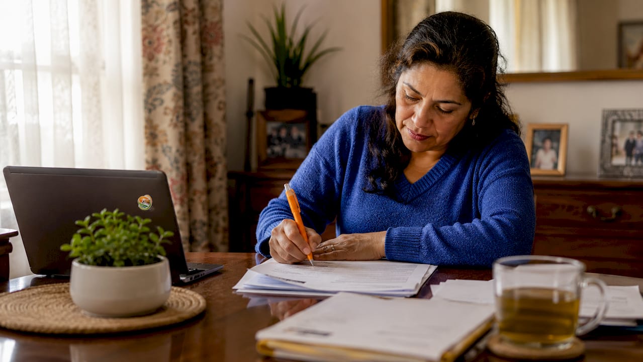 Woman signing home warranty transfer paperwork