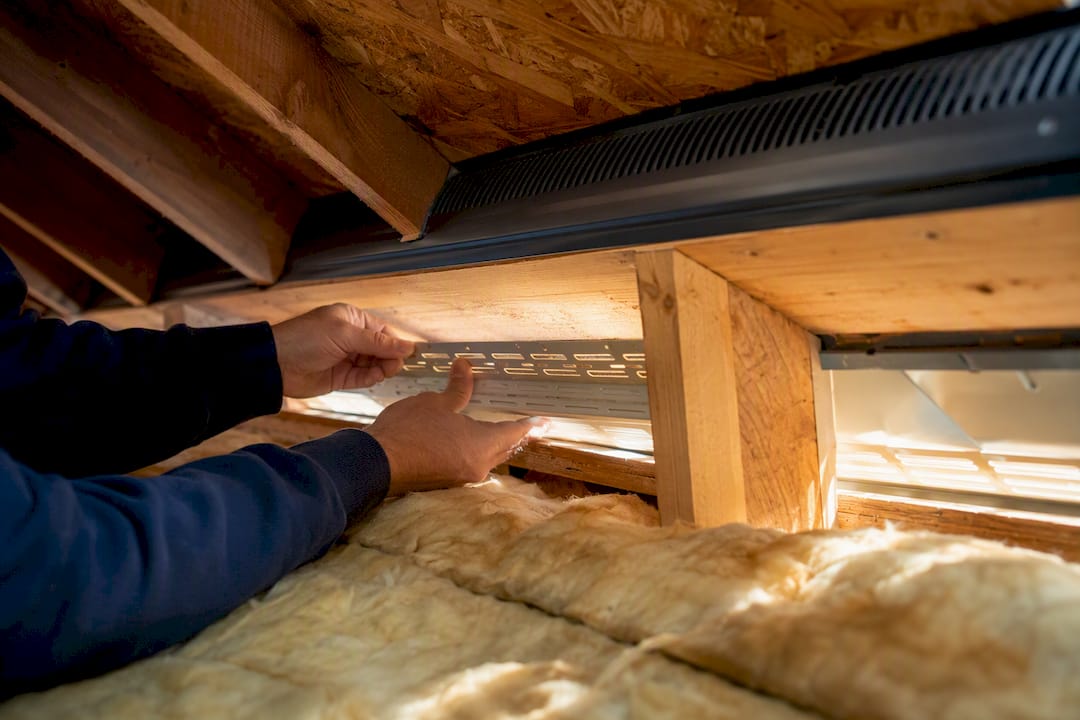 Attic ridge vent installation with soffit vents visible