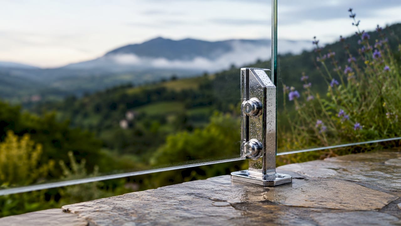 Close-up of stainless steel glass clamp on outdoor railing