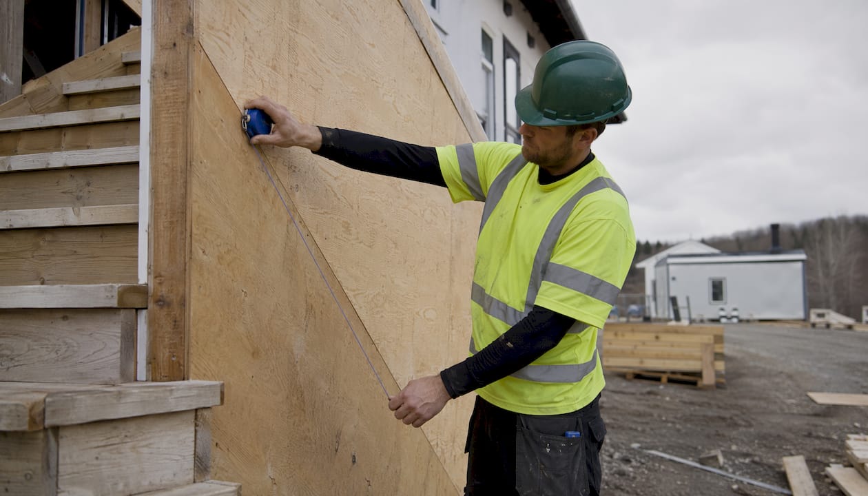 Worker marking stair wall with chalk line