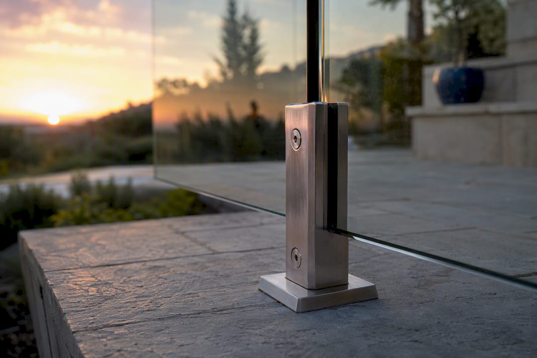 Spigot post supporting glass railing on deck