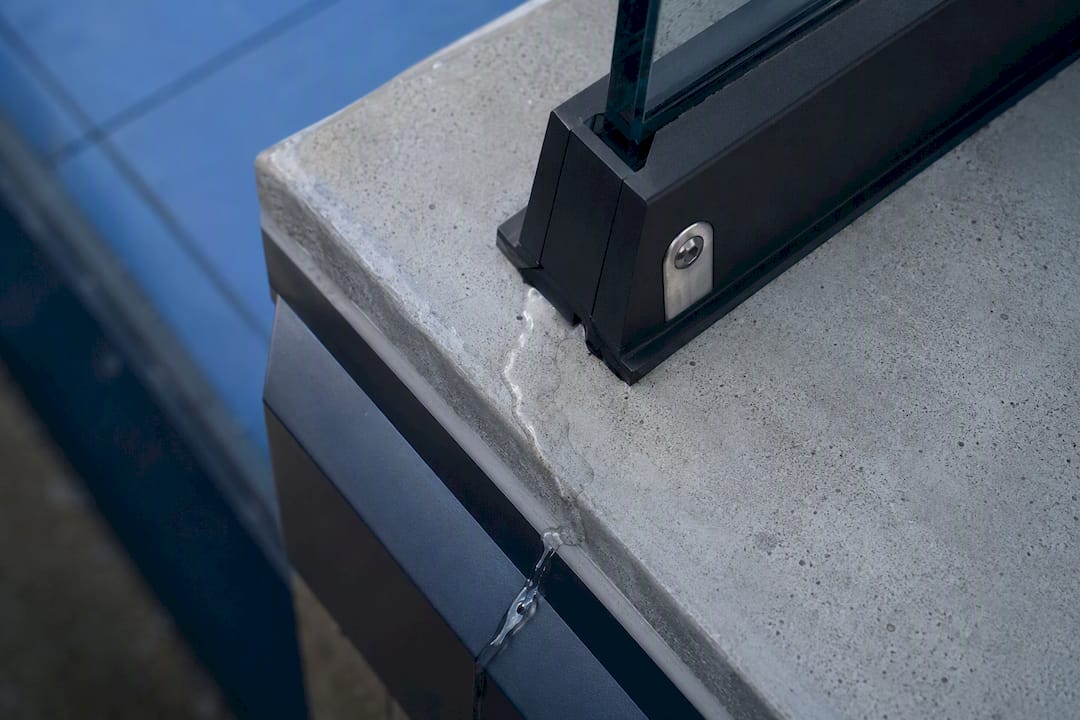Rooftop railing base shoe draining rainwater