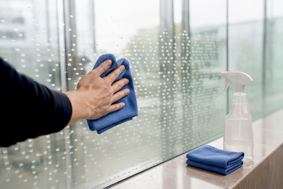 Technician gently cleaning patterned railing glass