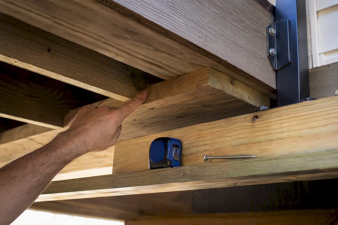 Installer checking structural blocking beneath deck