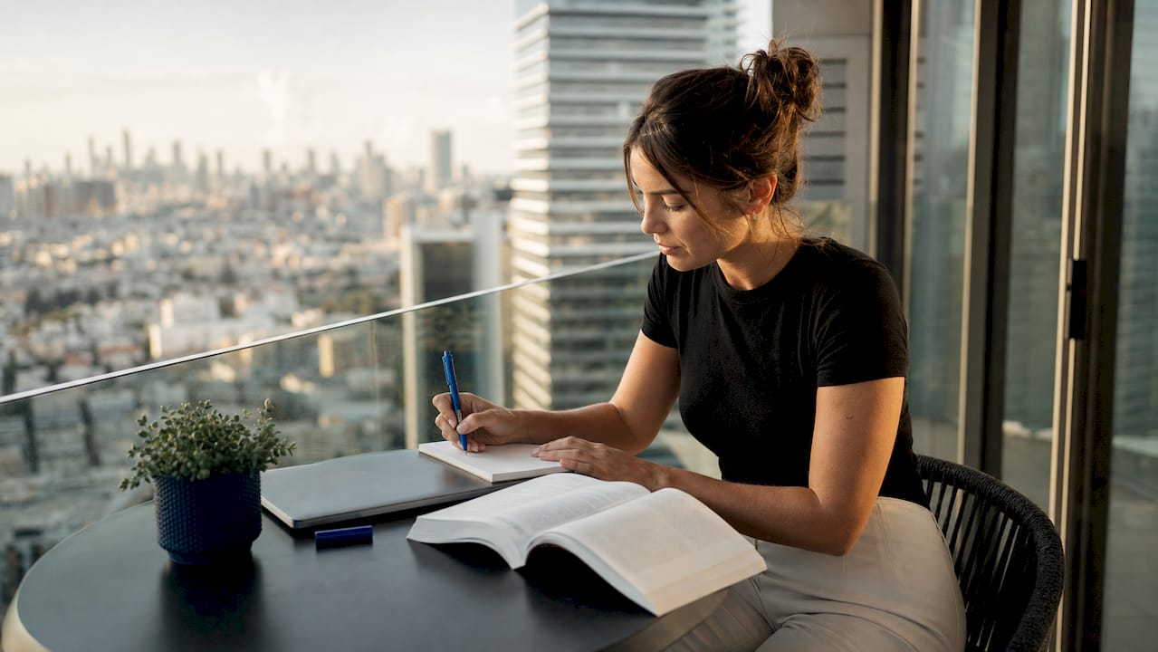 Young woman budgeting finances at home desk with documents