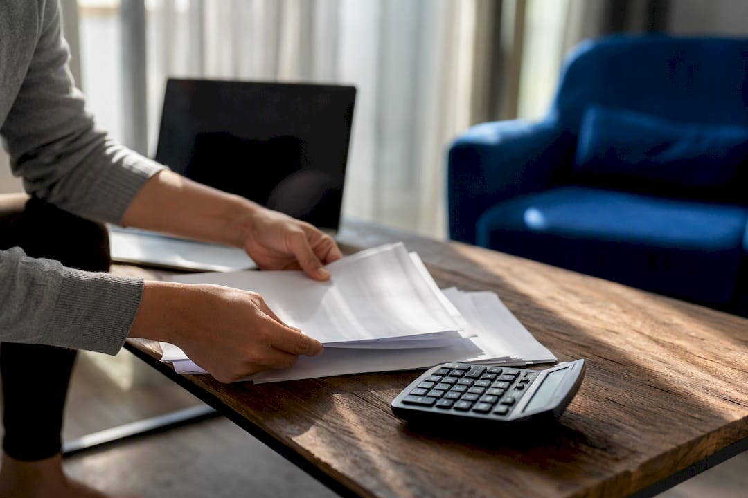 Hands organizing finance documents and calculator