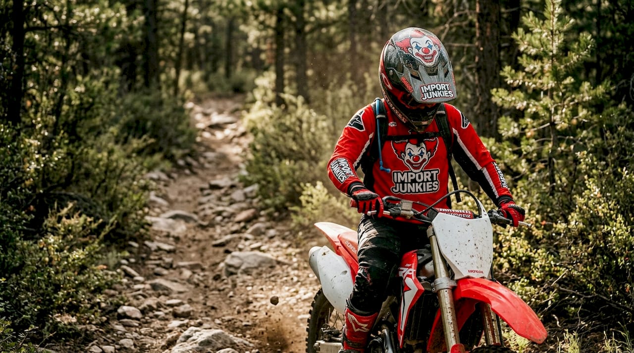 Dirt bike rider pauses at rocky trail entrance