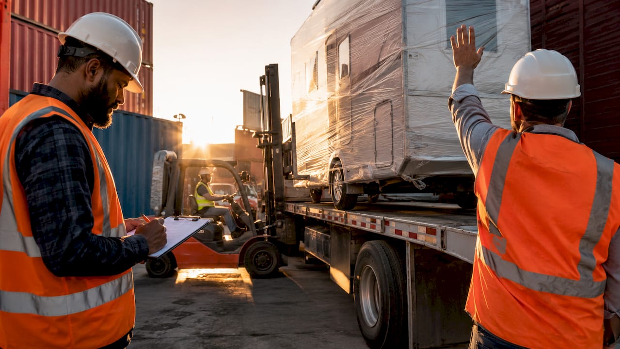 Logistics team loading recreational vehicle for shipment