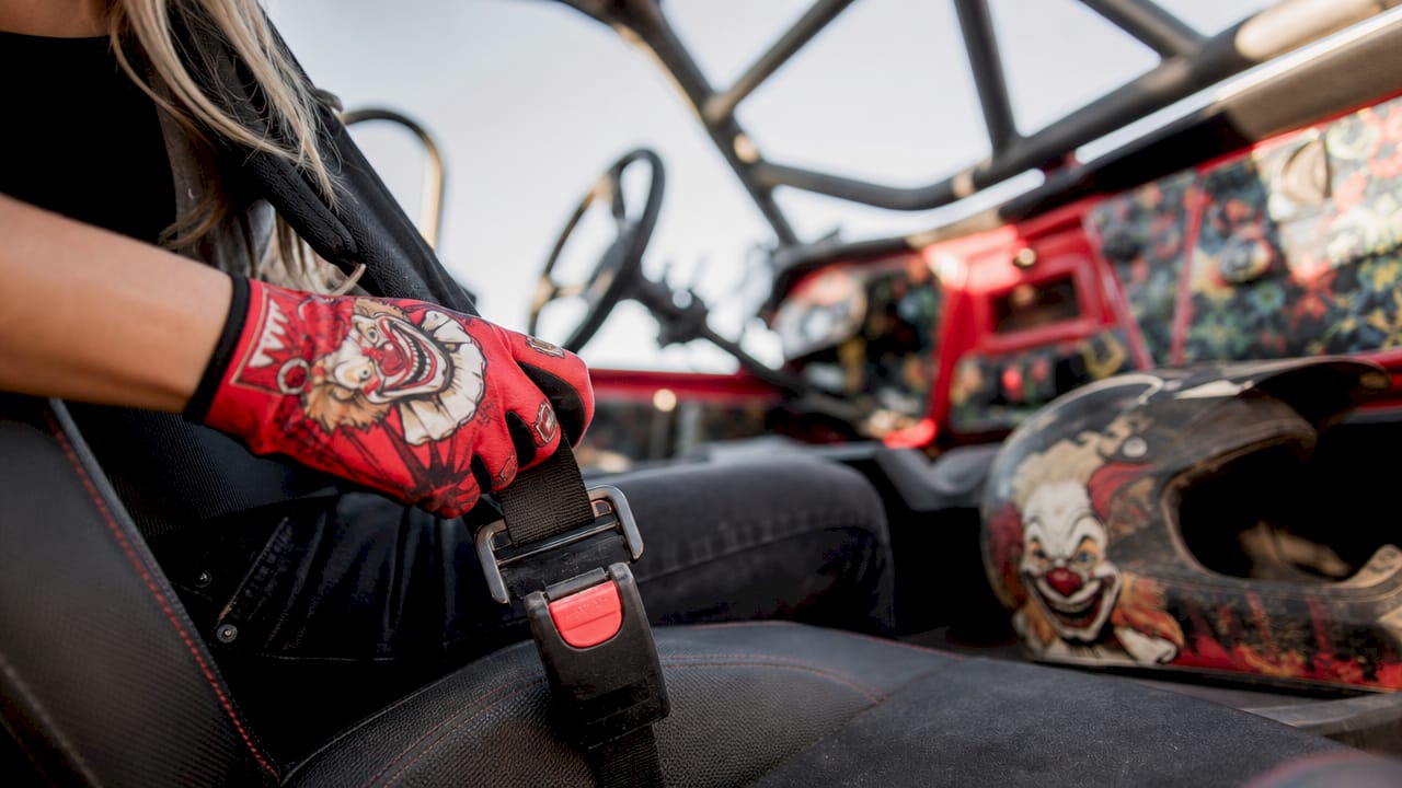 Close-up of hand fastening UTV seatbelt inside vehicle
