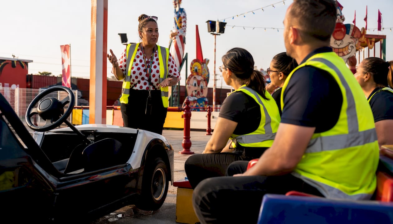 Safety trainer instructing course staff beside LSV outdoors