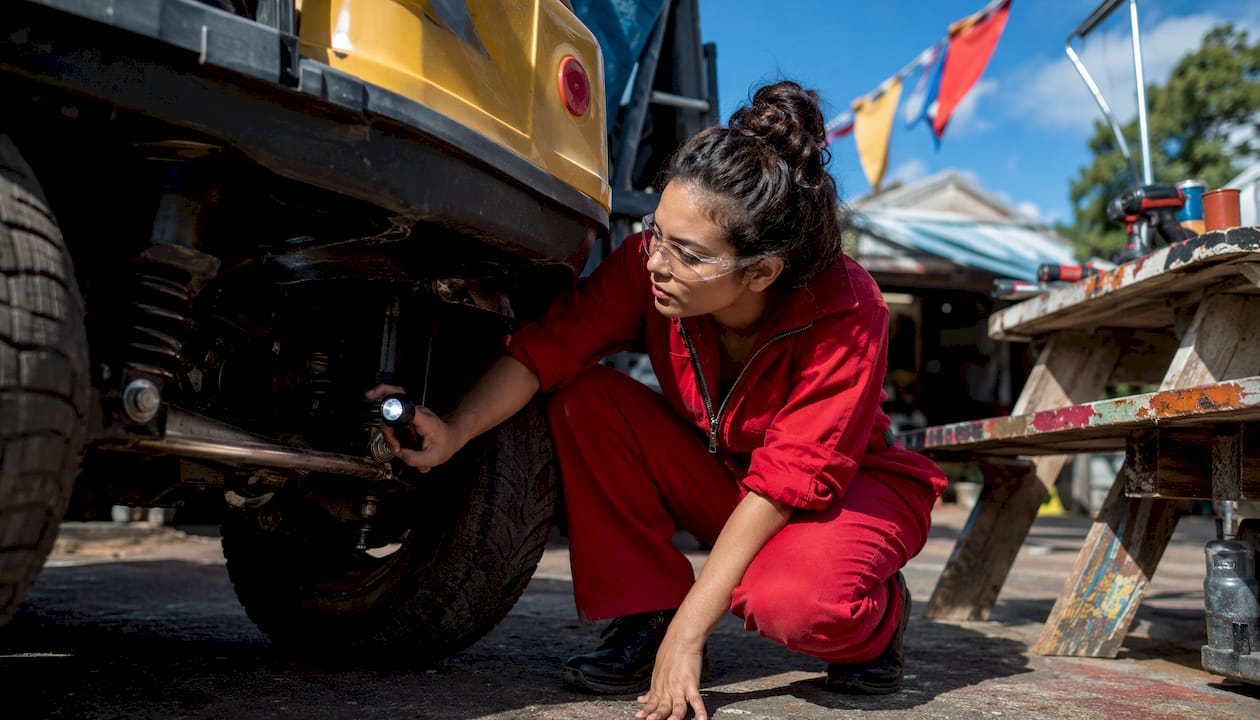 Female mechanic inspecting golf cart in garage