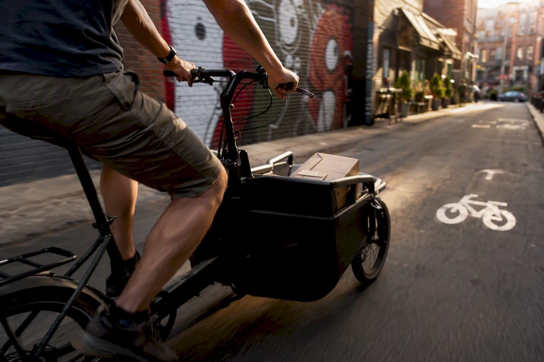 Courier on partial cargo bike in city
