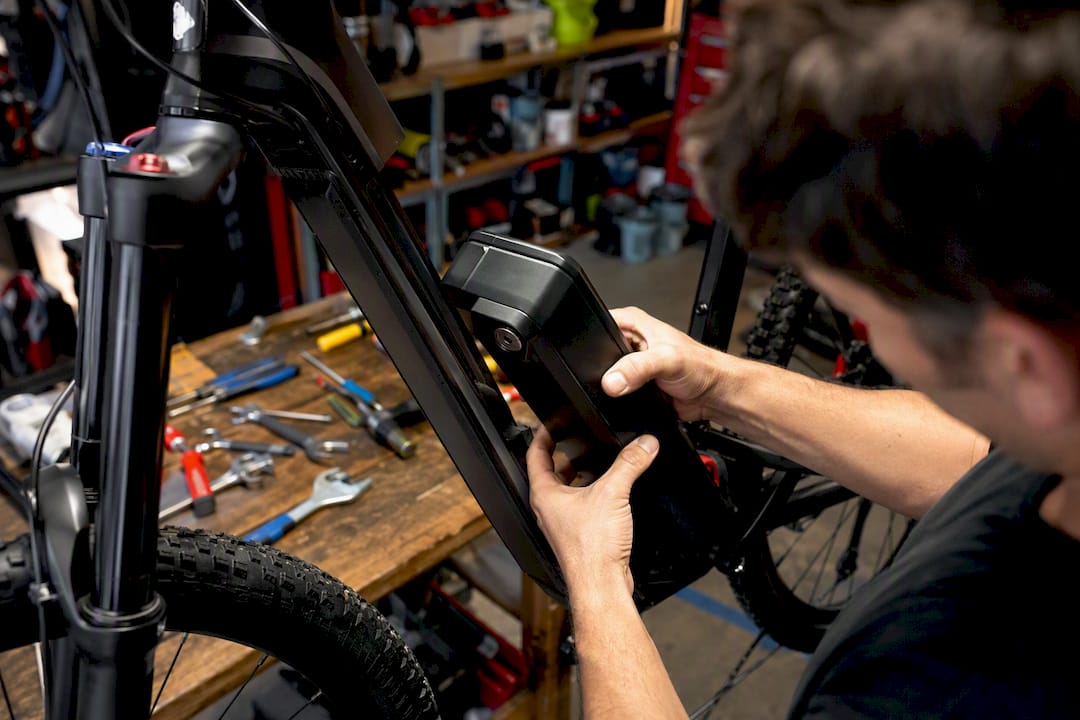 Hands removing ebike battery pack for replacement