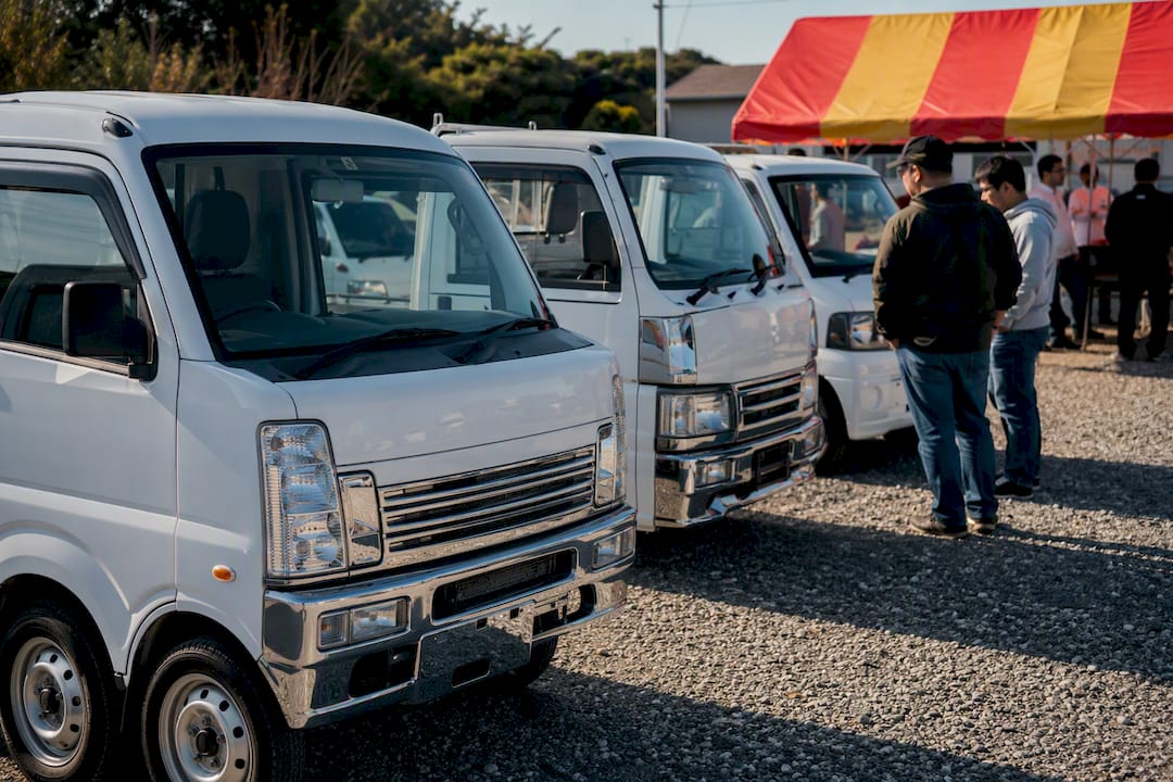 Buyers examining kei trucks outdoors