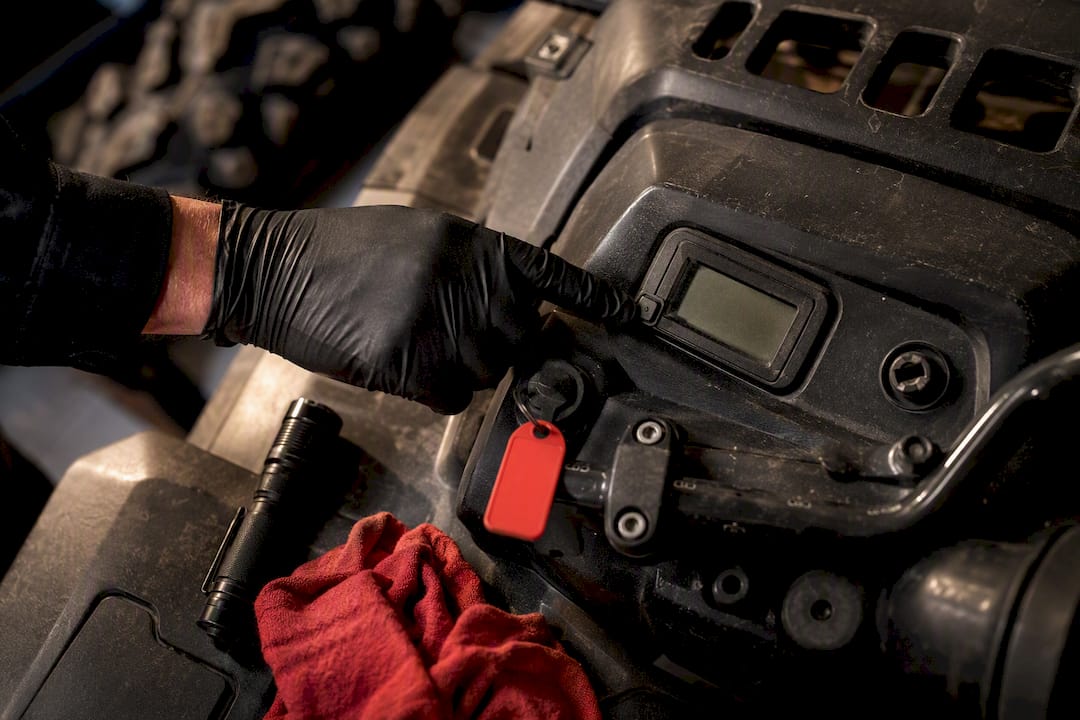Technician checking ATV hour meter