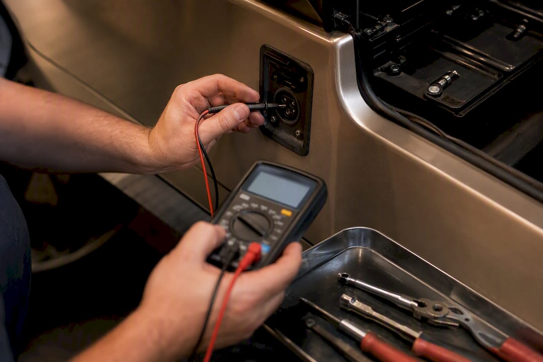 Technician testing golf cart charge port voltage