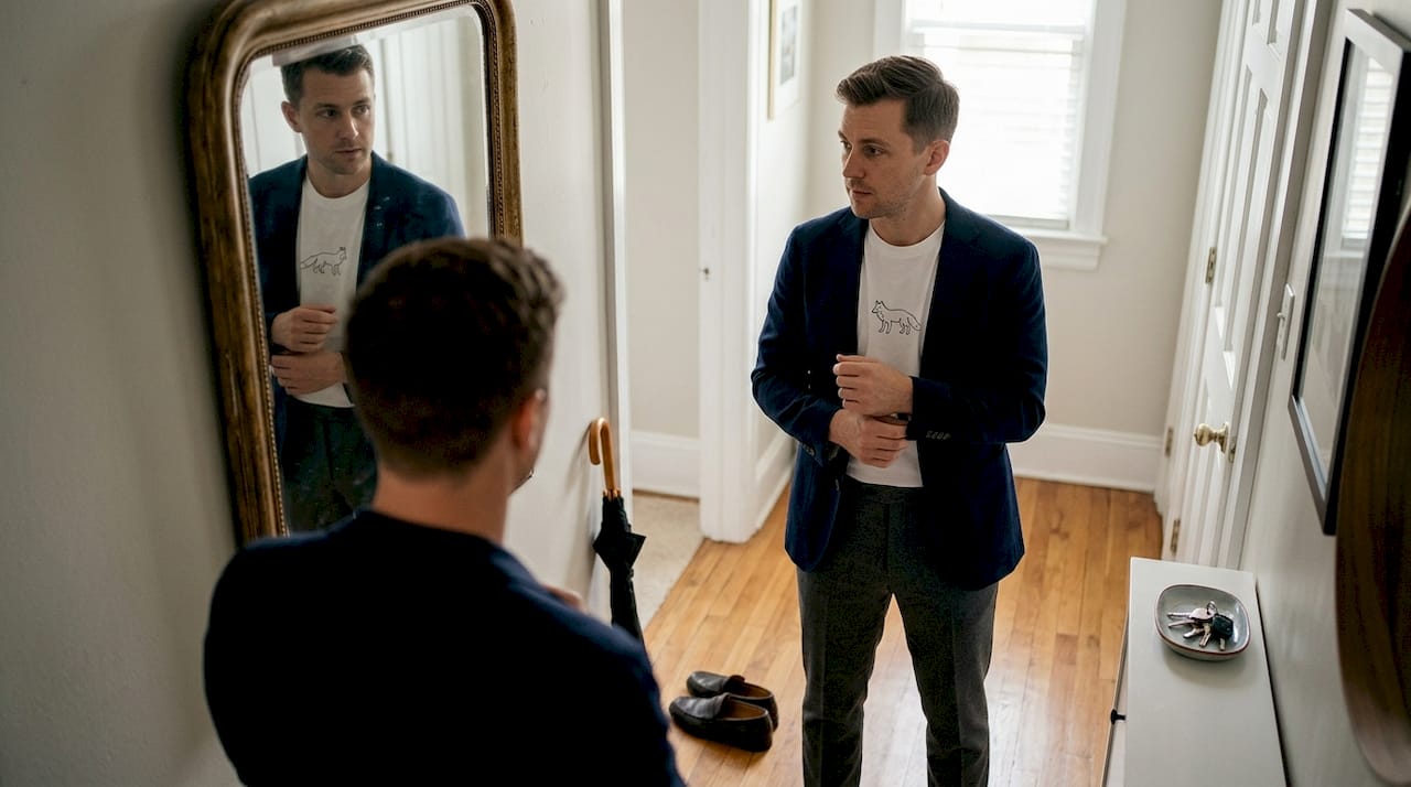 Man styles animal tee with blazer in hallway