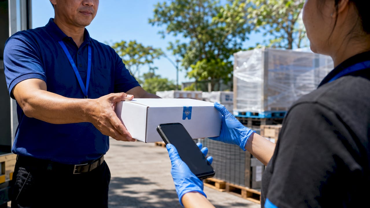 Hands exchanging sealed pharmaceutical package in warehouse