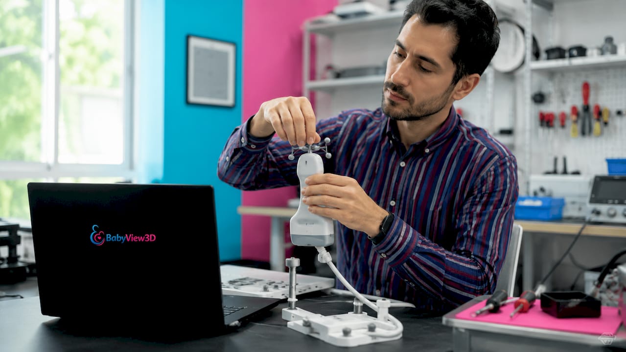 Unas manos realizan ajustes en un equipo de ultrasonido 3D.