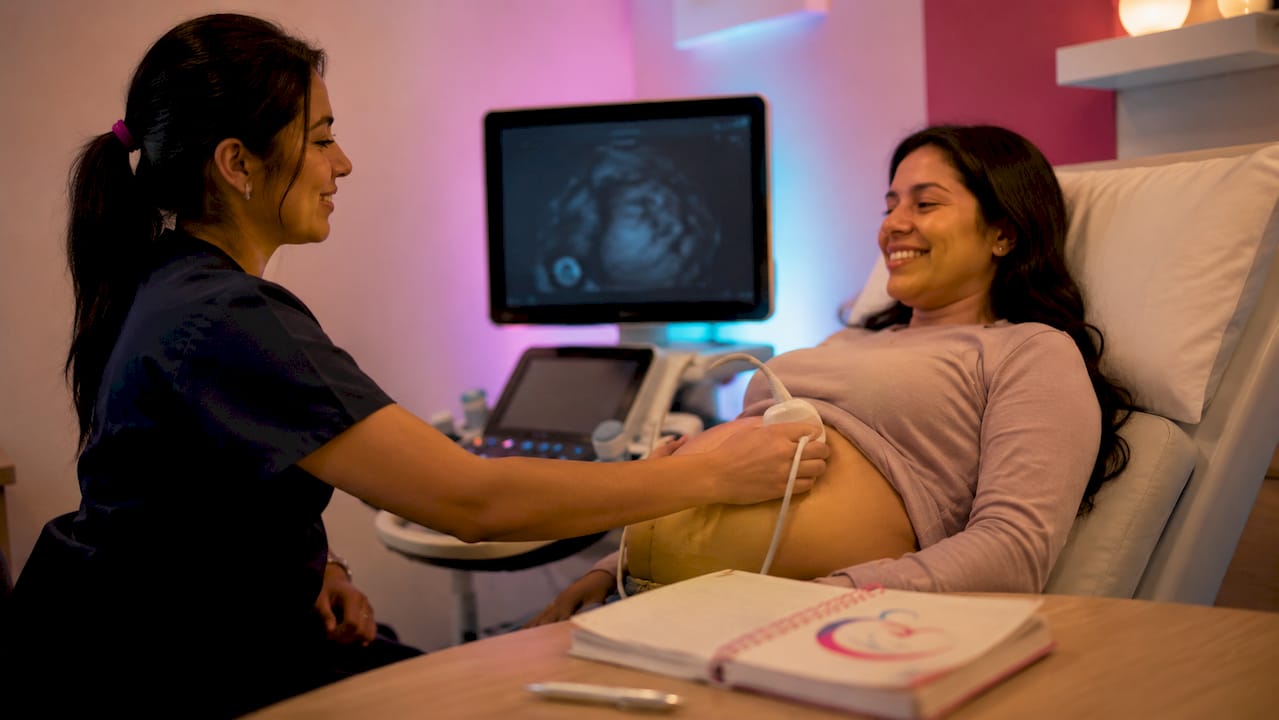 Detalle de las manos de un especialista realizando una ecografía fetal de alta precisión