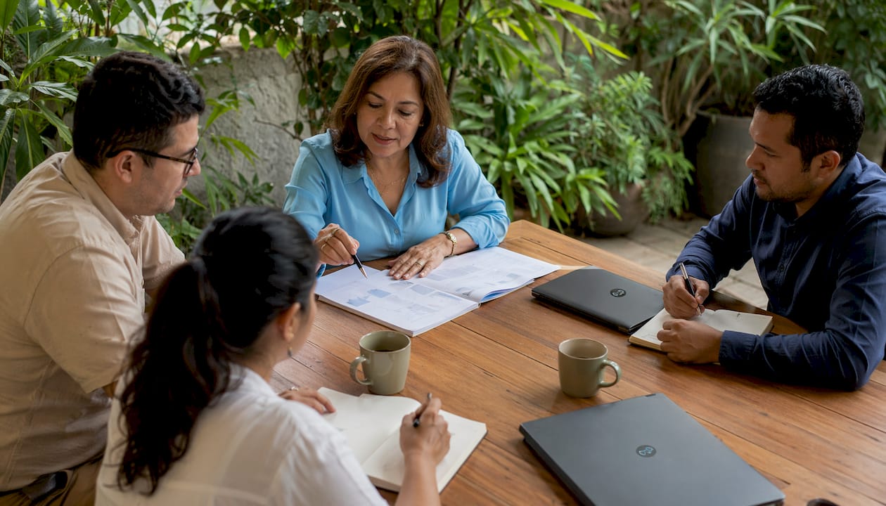 Director guiando una reunión de equipo para fortalecer la colaboración y alcanzar objetivos comunes.