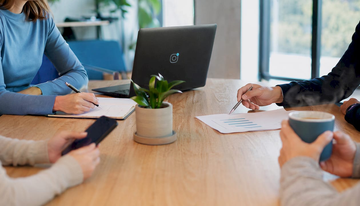 Varias personas colaborando alrededor de una mesa de trabajo
