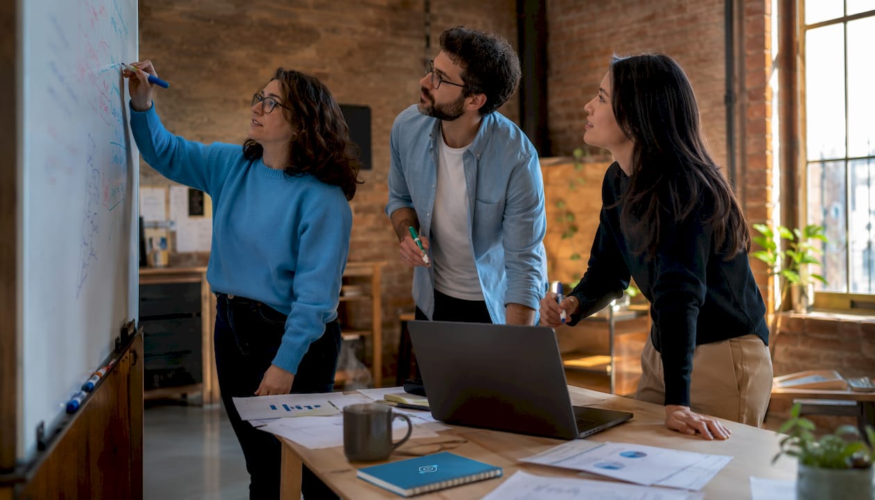 Unas manos anotando los KPIs en una pizarra blanca