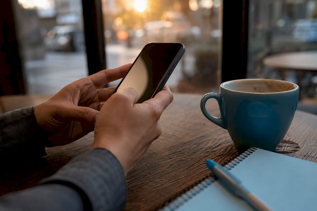 Manos sujetando un teléfono con la pantalla apagada