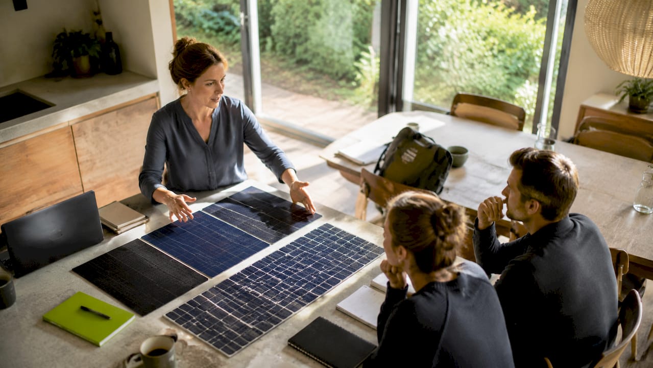 Ein Ingenieur stellt in einer Besprechung verschiedene Muster von Solarzellen vor.