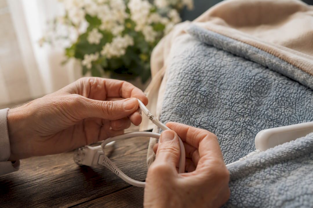 Hands inspecting electric blanket cord for safety