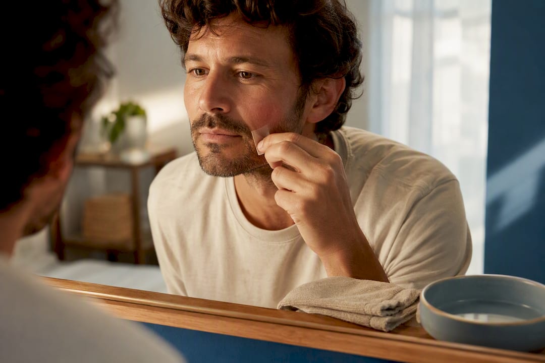 Adult removing adhesive from mildly irritated cheek