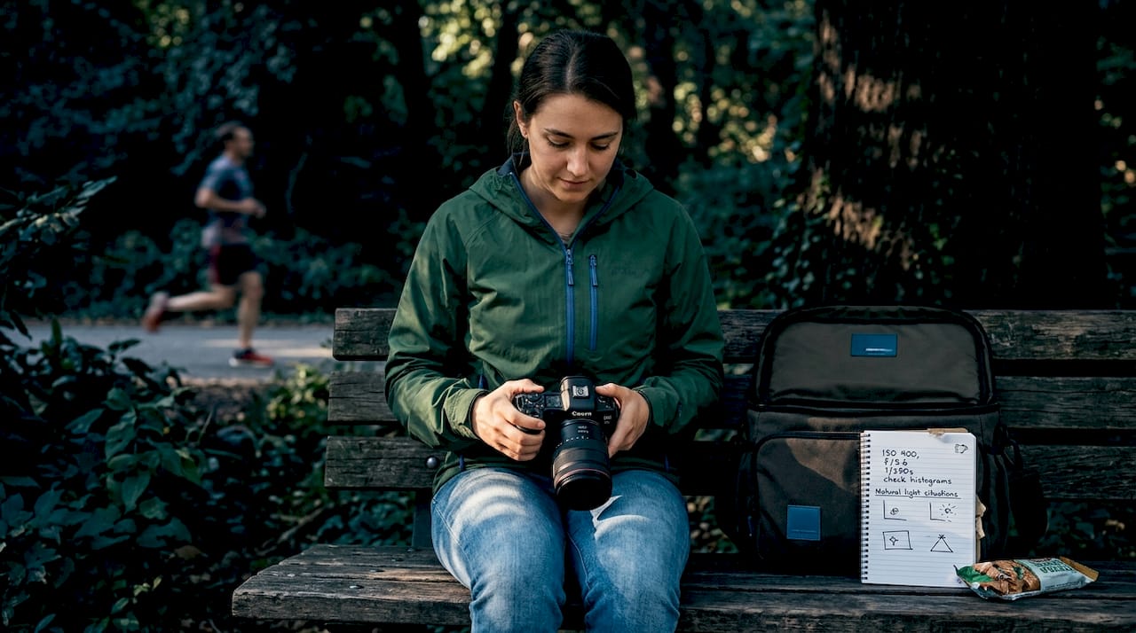 Photographer adjusting camera settings outdoors