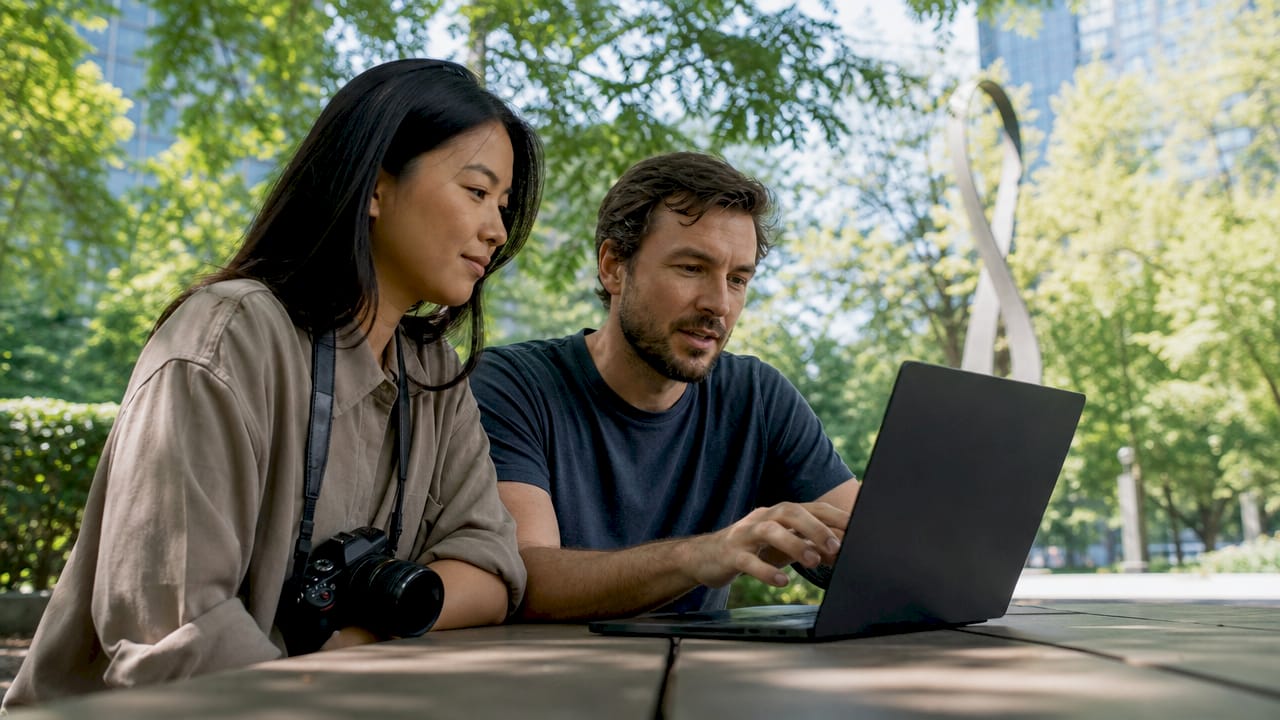 Two photographers discussing editorial images outdoors