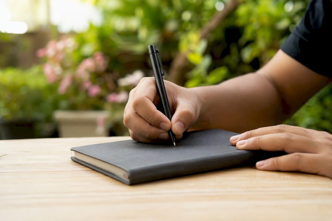 Primer plano de una mano escribiendo una respuesta abierta