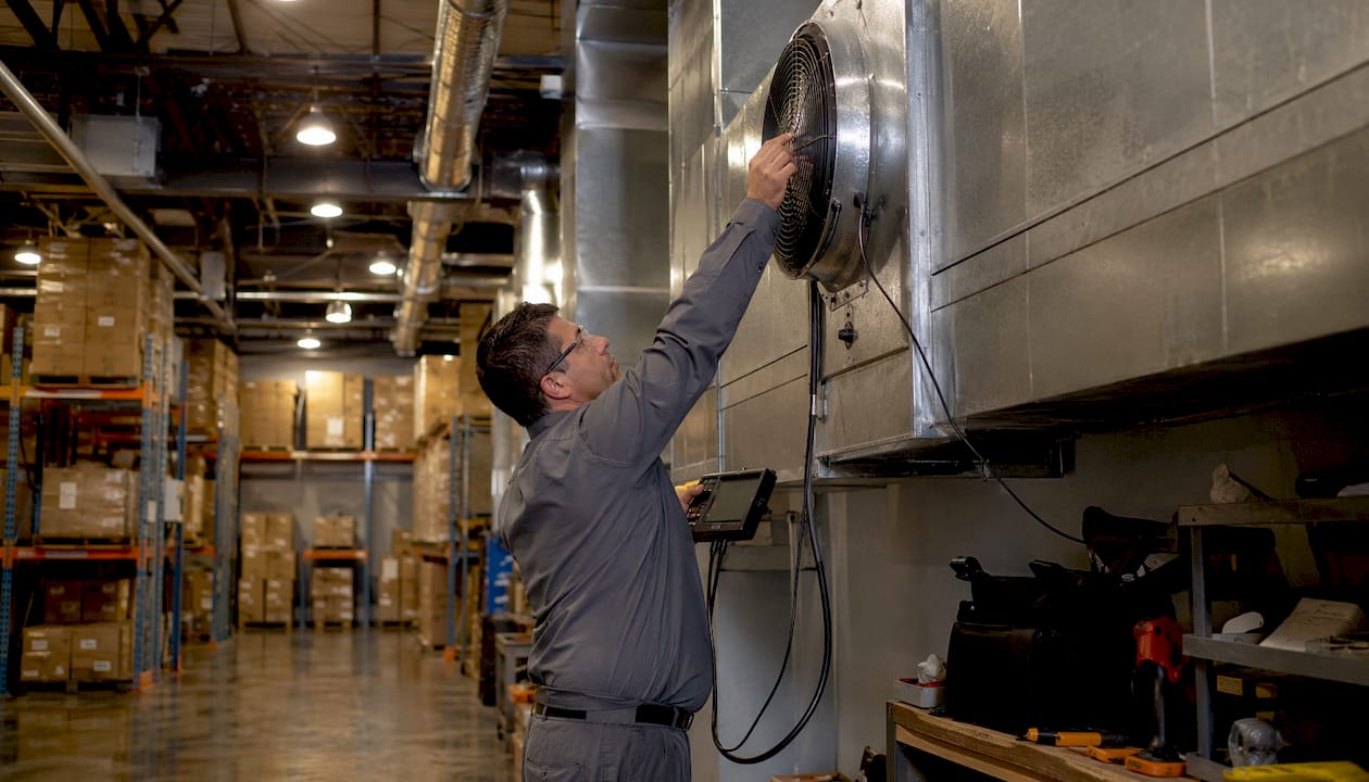 Technician inspecting mechanical ventilation system