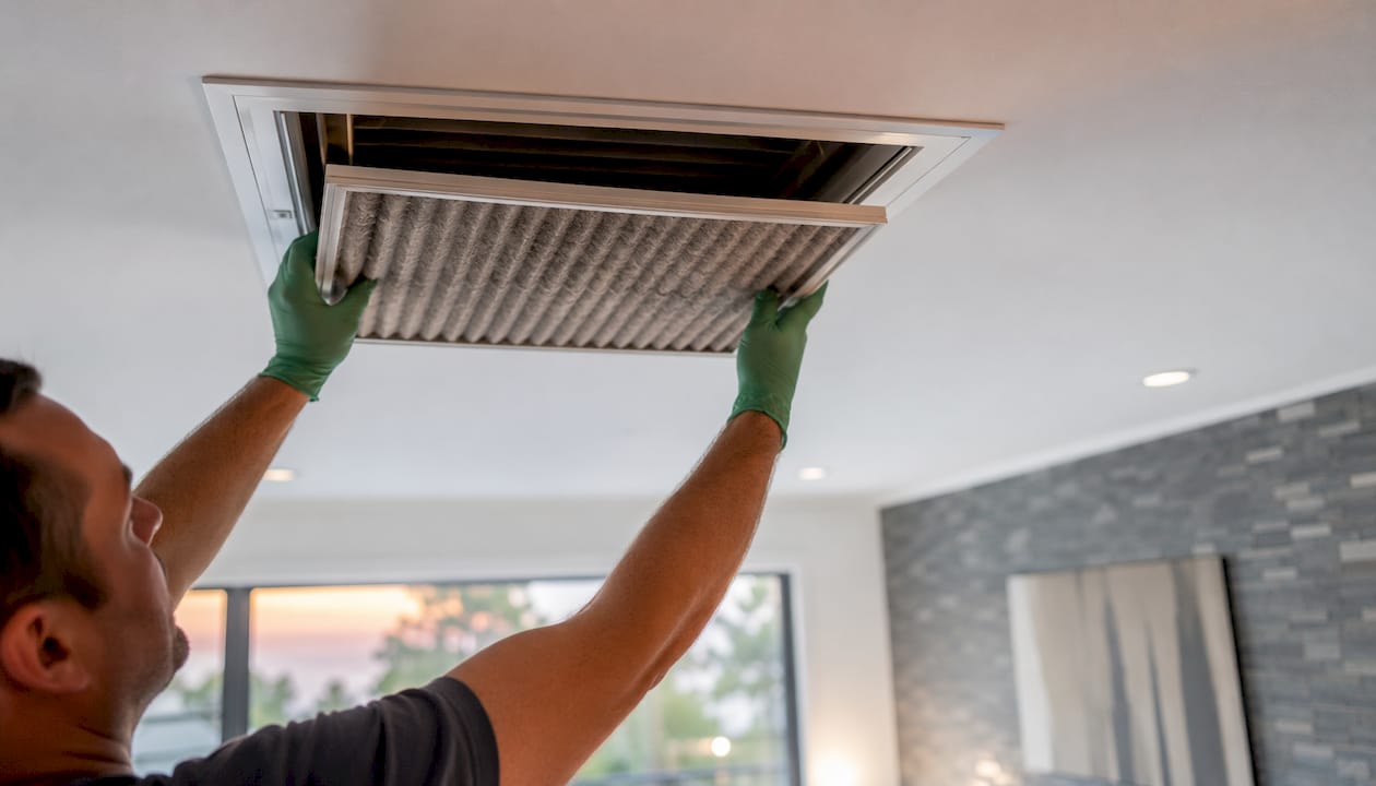 Technician replacing dirty HVAC air filter