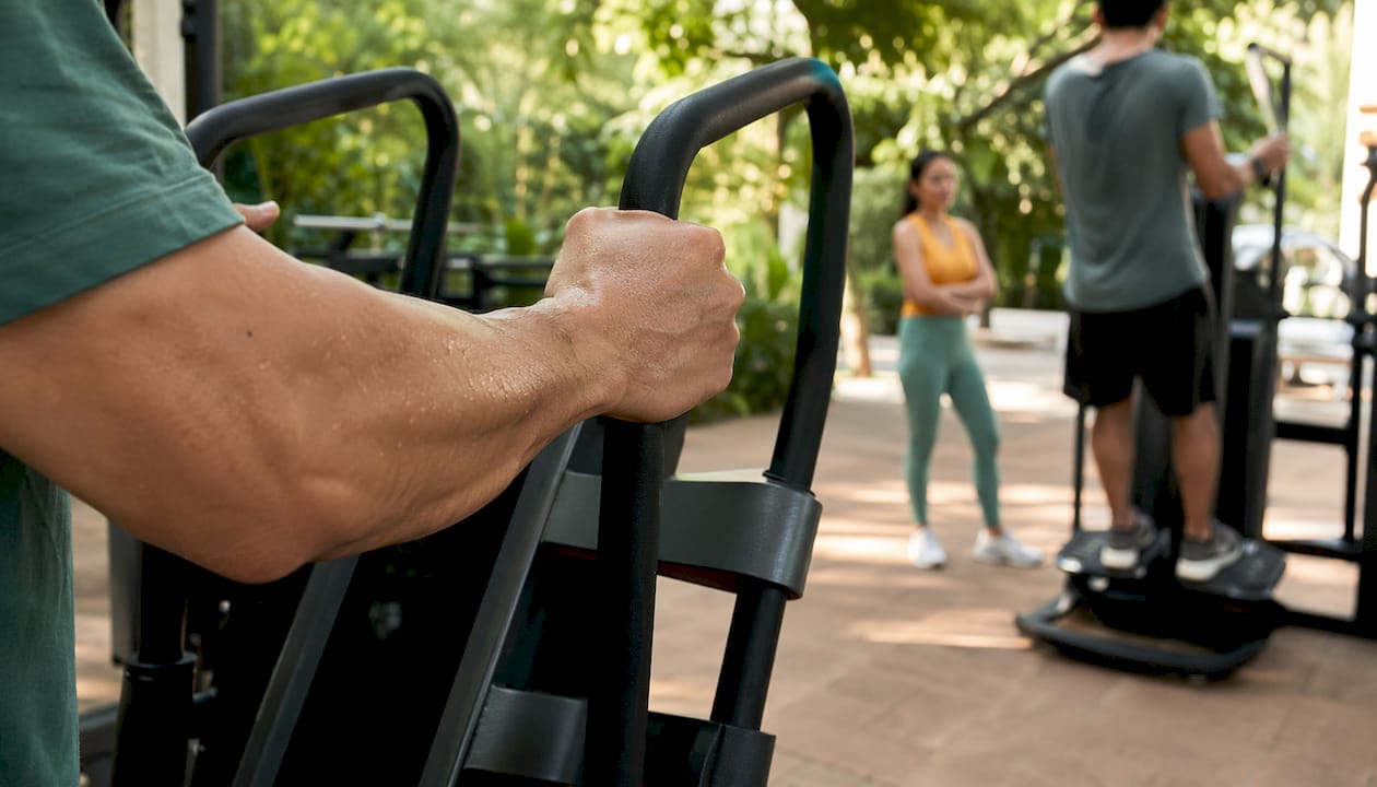 Hands gripping whole body vibration machine handrails