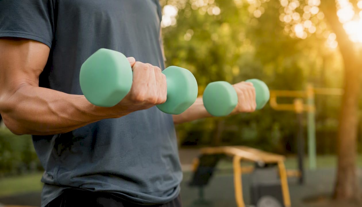 Hands holding dumbbells during strength training