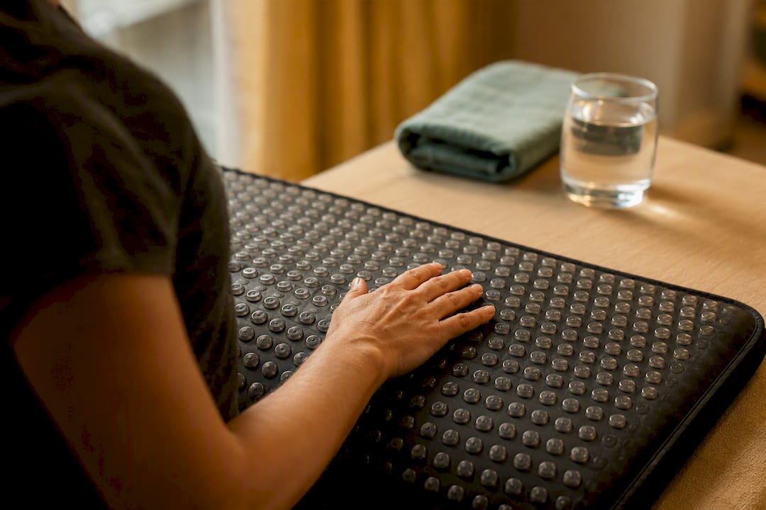 Hand on vibroacoustic therapy mat close-up