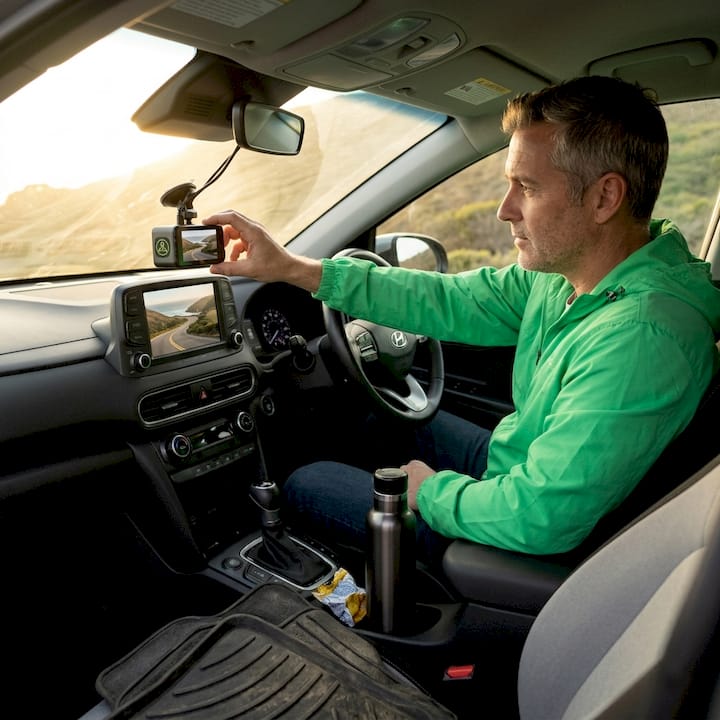 Driver reviewing dashcam footage at rest stop