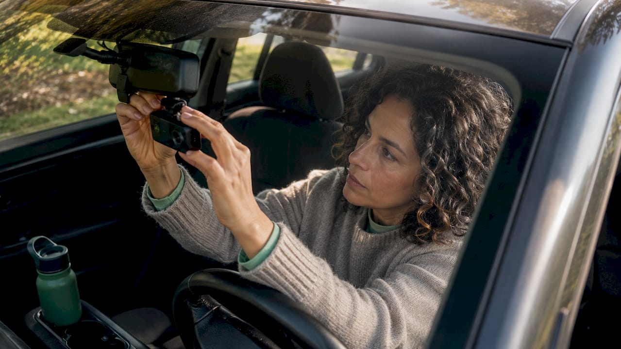 Driver installing dashcam inside car