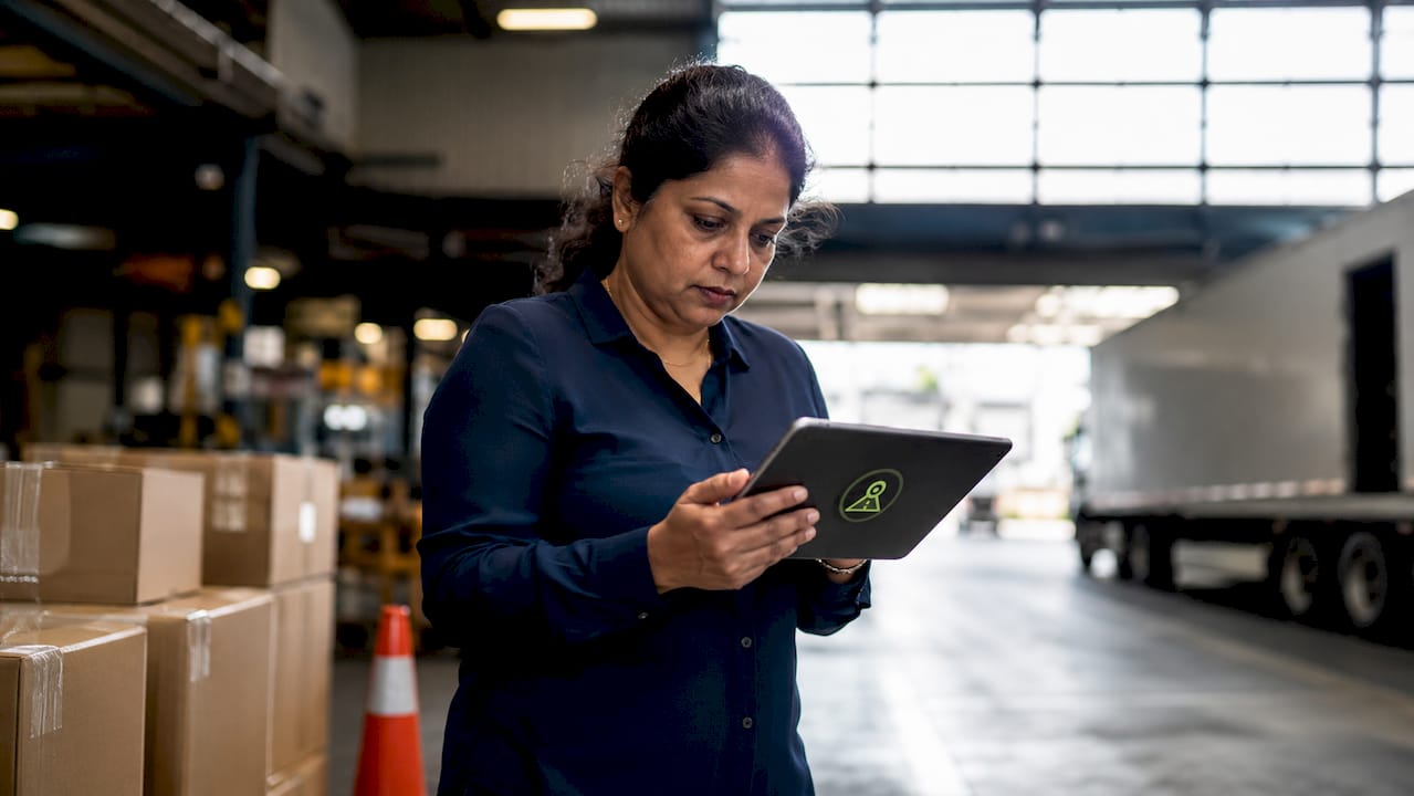 Logistics manager reviewing dashcam footage at warehouse desk