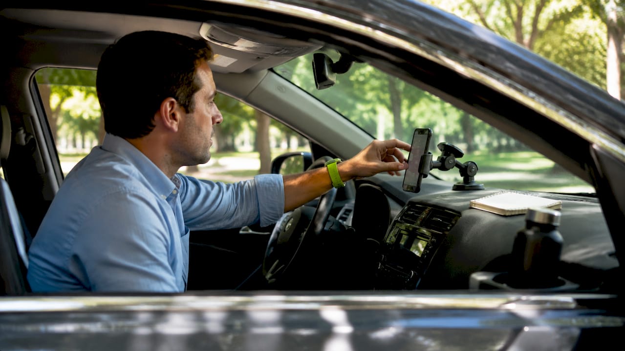Driver setting up dashcam app on Android phone