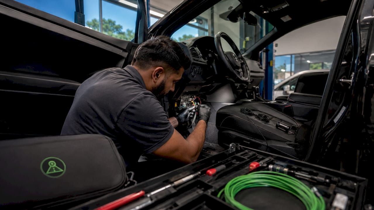 Technician hardwiring dashcam into fuse box