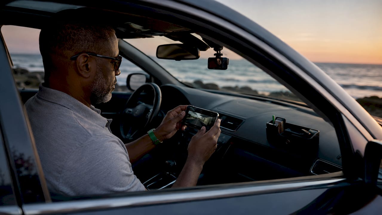 Driver reviewing dashcam footage on smartphone